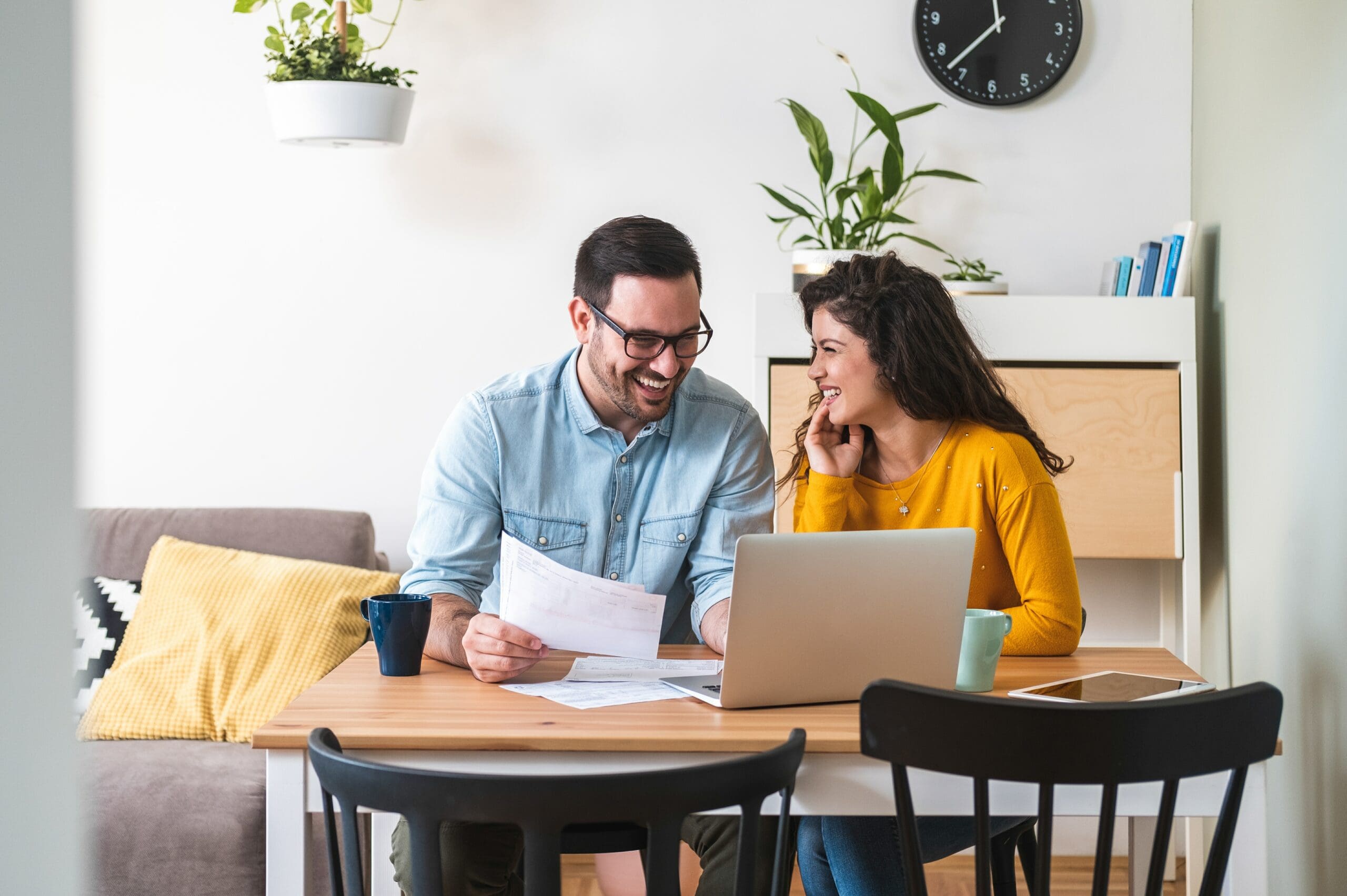 smilingcouplemanagingfinancesreviewingtheirbankaccountsusinglaptop