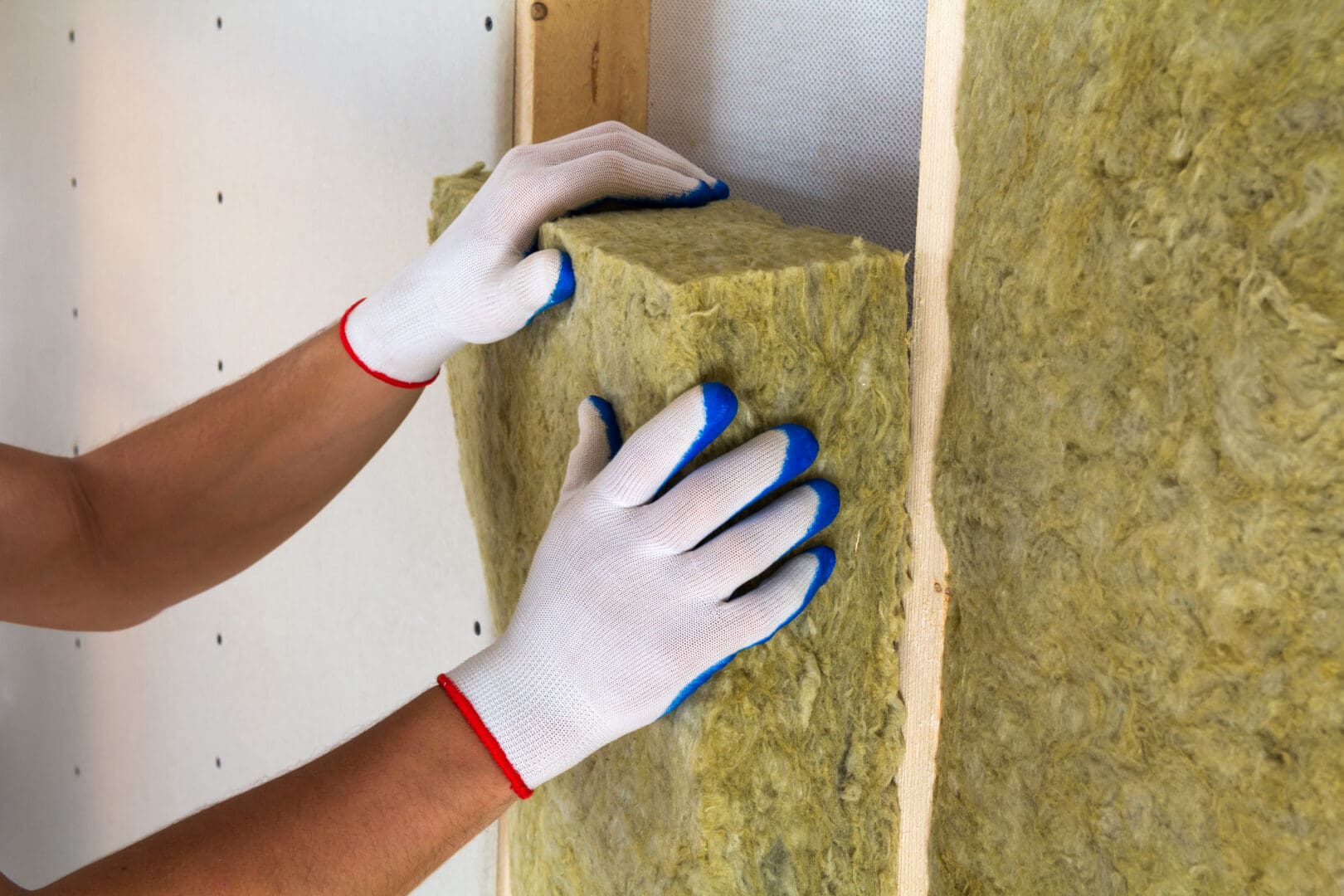 close-upofworkerhandsinwhiteglovesinsulatingrockwool-3